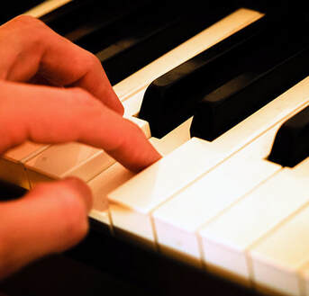 Fingers playing on a piano
